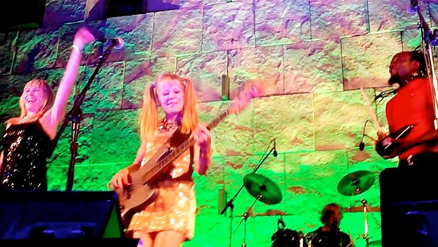 Tina Weymouth on bass in gold and pigtails, with vocalists, and Chris Frantz on drums in the background Tina (foreground) on bass in gold and pigtails, with vocalists, and Chris on drums in the background
