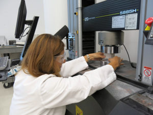 Permalink to Conservation Tools: The Universal Testing Machine (UTM) Associate Scientist Beril Bicer-Simsir placing a building material sample in the Universal Testing Machine.