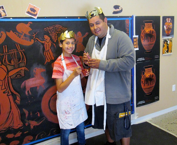 A family works on a mural for a sixth-grade performance of Homer's Odyssey