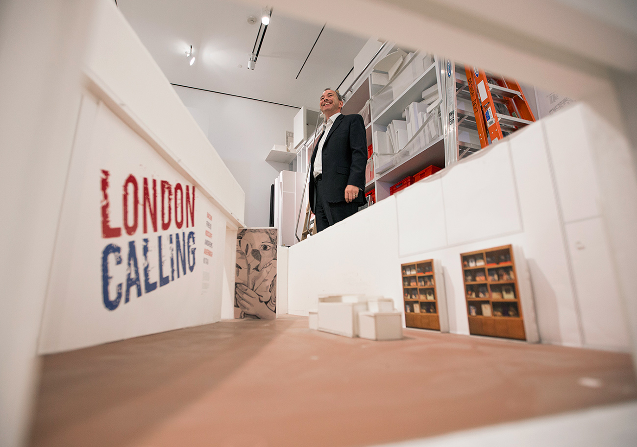 Getty Museum curator Julian Brooks smiles while standing beside a foam-core mockup of London Calling