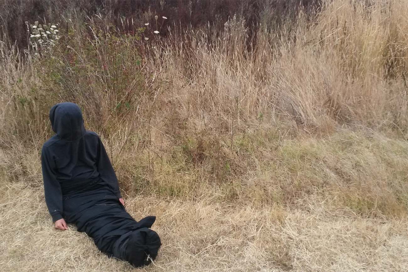 Enrobed in black, Marbles Jumbo Radio sits on the ground during performance of Mountain, Fire, Holding Still. Enrobed in black, Marbles Jumbo Radio sits on the ground during performance of Mountain, Fire, Holding Still.