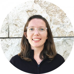 Krystal Boehlert smiling, standing against a travertine wall at the Getty