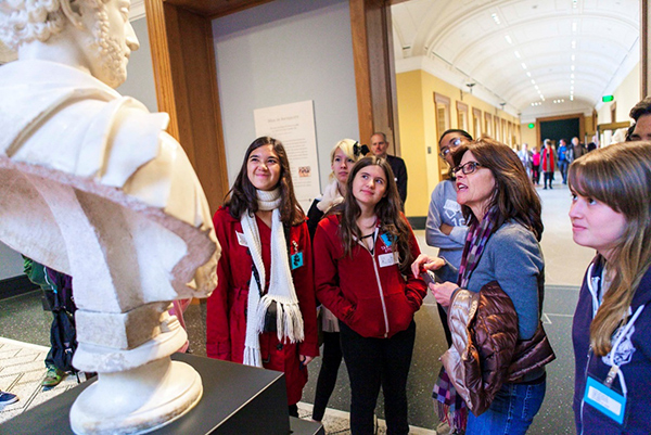 High school students in conversation with docent Barbara Atherton as they examine the Bust of Commodus.
